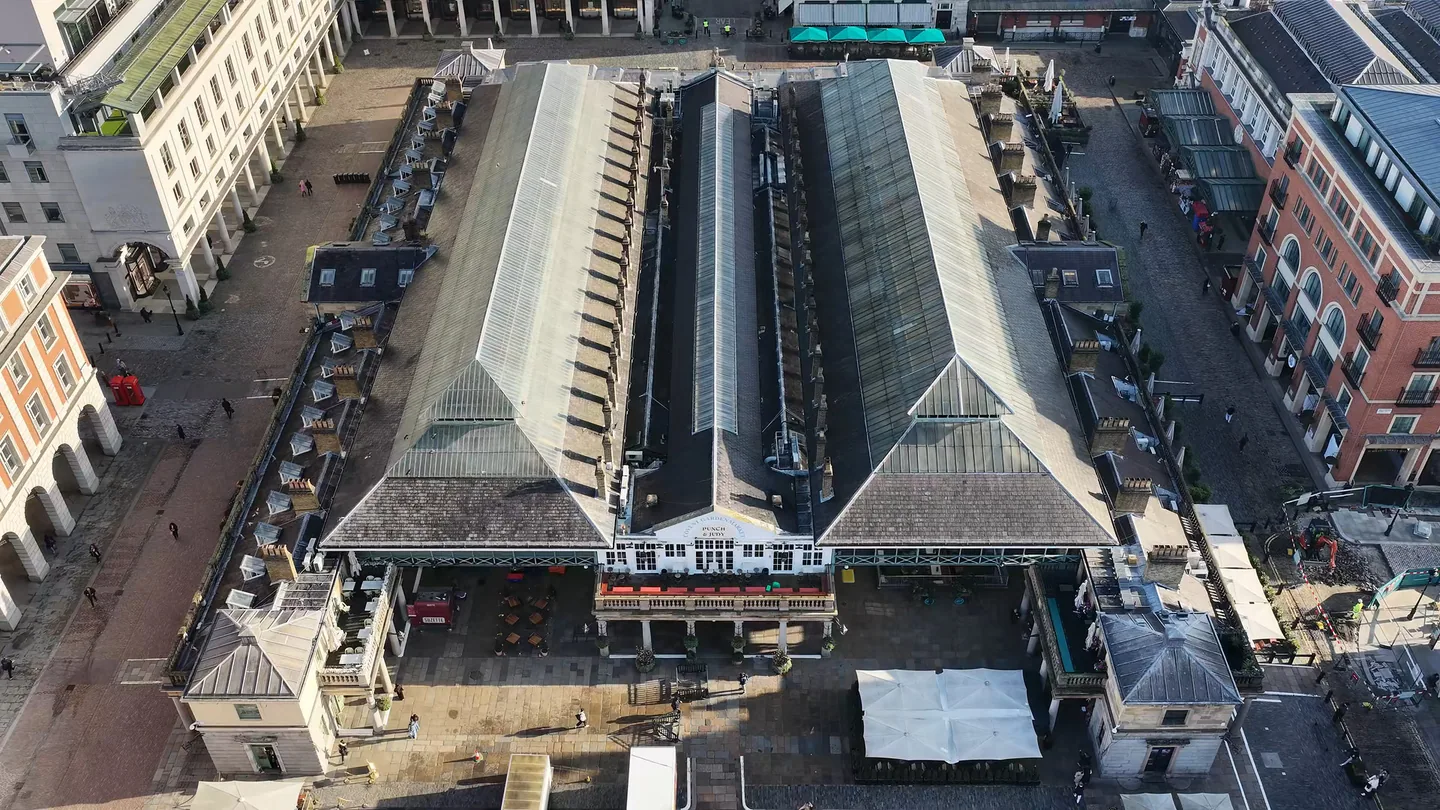 Drone view looking down on the glazed and slate roofs of the Covent Garden Market building, with the surrounding piazza and terraces