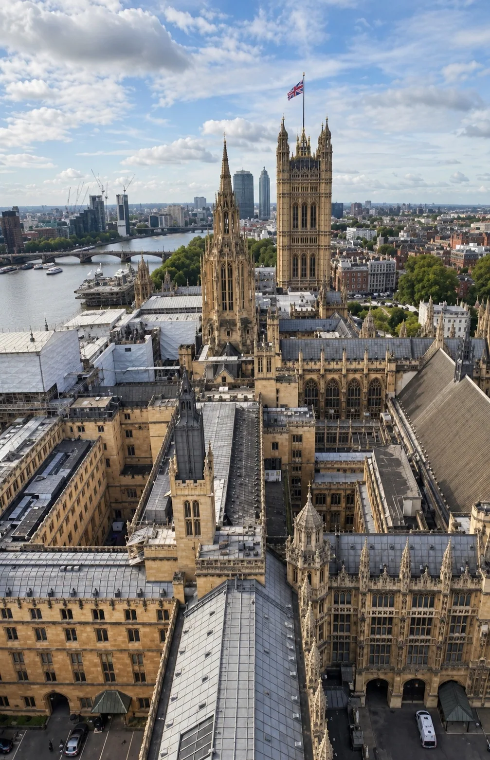 Aerial view over the roofs and courtyards of the Houses of Parliament towards Victoria Tower, with the Thames on the left