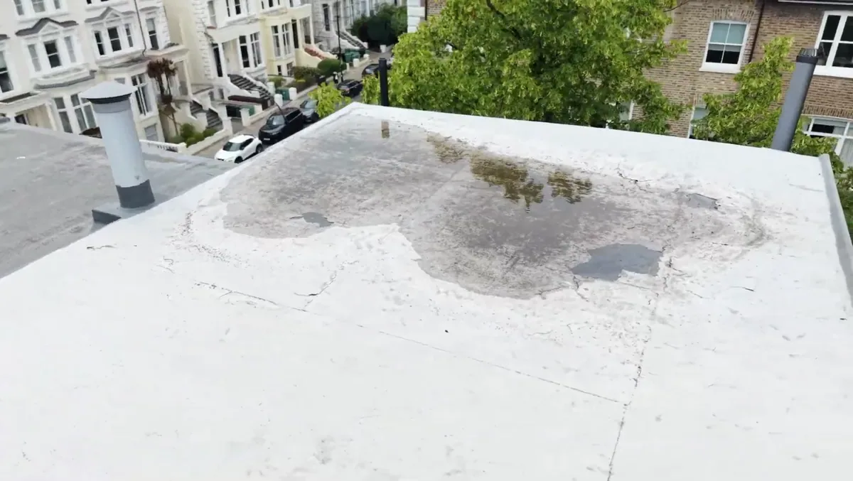 Flat roof with standing water and staining across the membrane